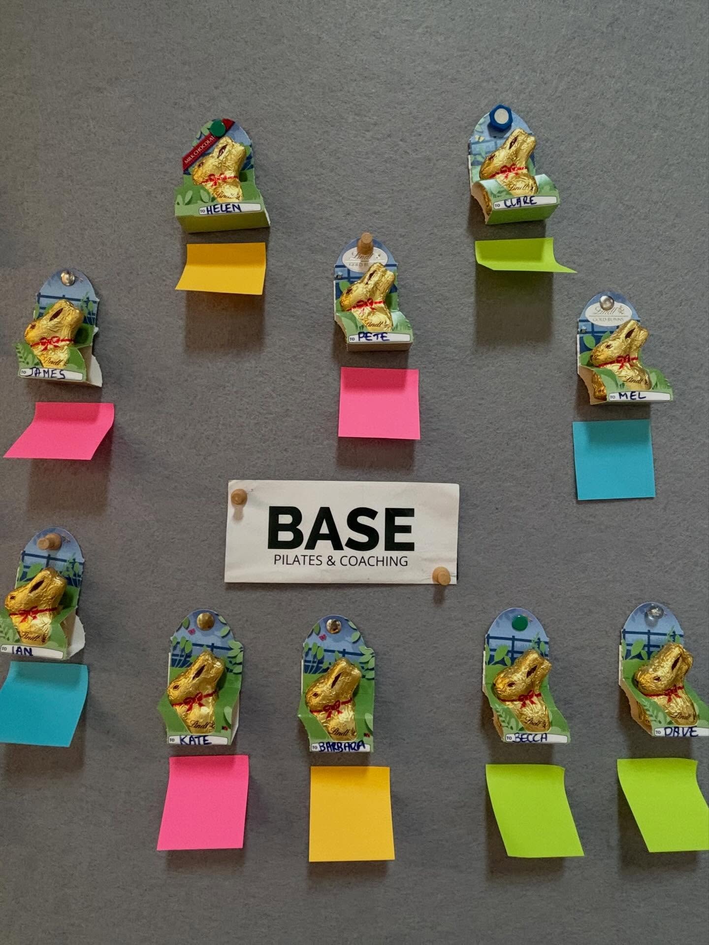 The BASE Pilates & Coaching sign on a noticeboard, surrounded by chocolate Easter bunnies labelled with class members’ names